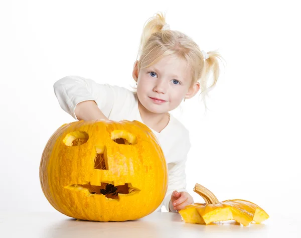 Liten flicka snidning pumpa till halloween — Stockfoto