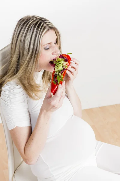 Mulher grávida comendo pimenta vermelha — Fotografia de Stock