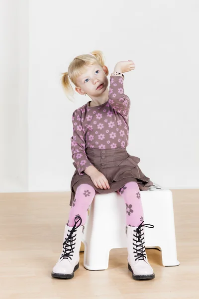 Sitzendes kleines Mädchen mit einem Armband — Stockfoto