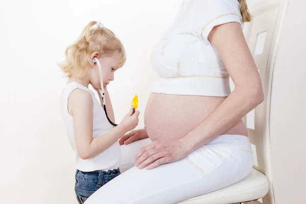 Meisje zorgzame na haar zwangere moeder — Stockfoto