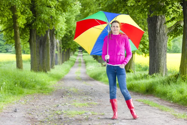 Vrouw in rubberen laarzen met paraplu — Stockfoto