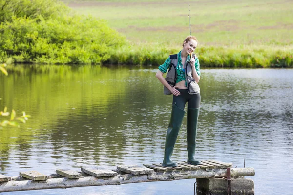 Genç kadın gölet iskelede Balık tutma — Stok fotoğraf