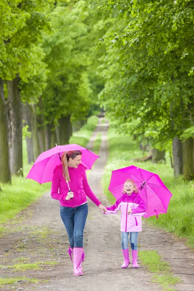 Mor och hennes dotter med paraplyer — Stockfoto