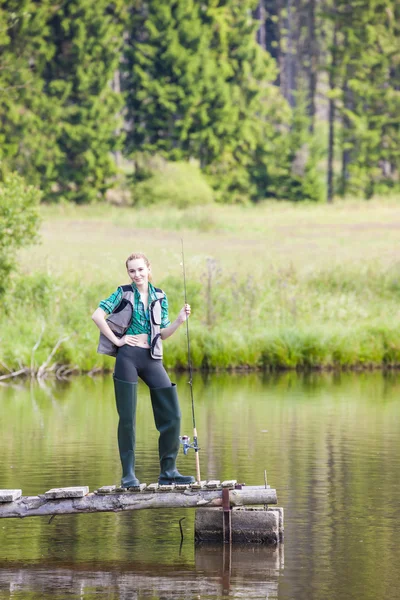 Giovane donna pesca sul molo a stagno — Foto Stock