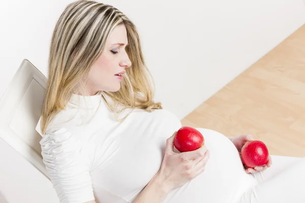 Портрет беременной женщины с красными яблоками — стоковое фото