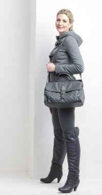 bir çanta ile gri elbise giyen kadın