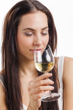 Genç kadın beyaz şarap tadıyor.