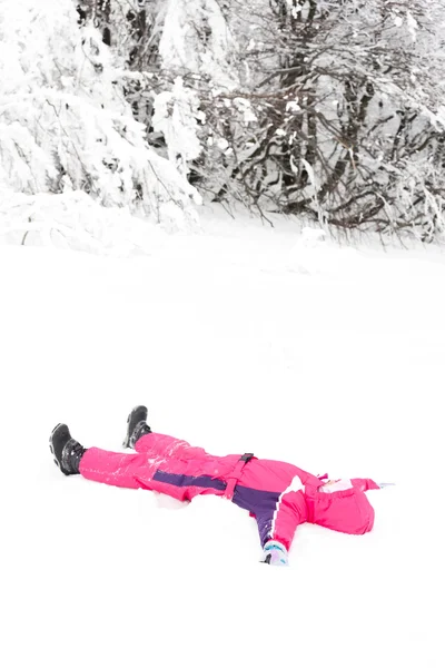 Lille pige leger i sne - Stock-foto
