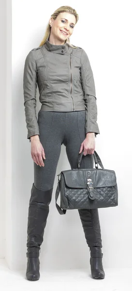 Femme portant des vêtements gris avec un sac à main — Photo