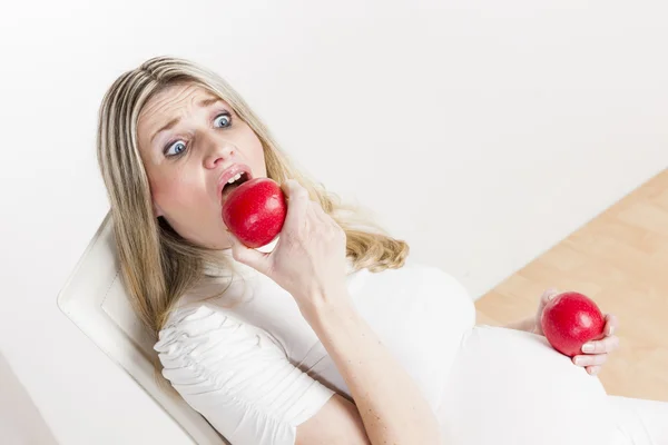 Mulher grávida comendo maçã vermelha — Fotografia de Stock