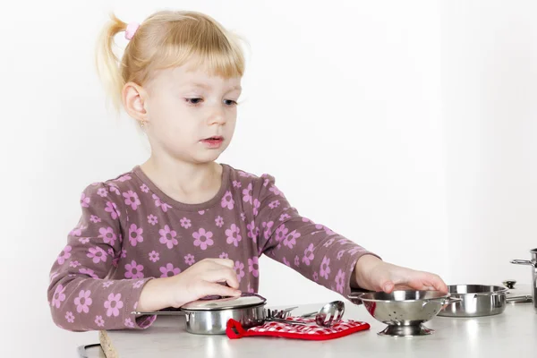 Little girl playing with child dish — Stock Photo, Image