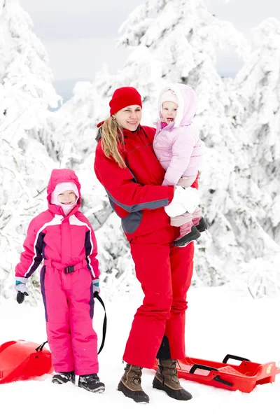 Mother and her little daughters with bobs in snow — Stock Photo, Image