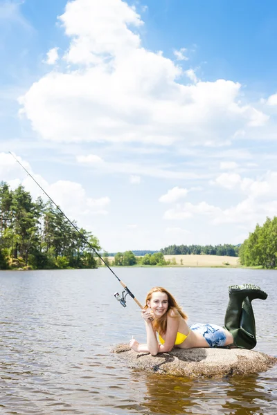 Mulher pesca na lagoa durante o verão — Fotografia de Stock