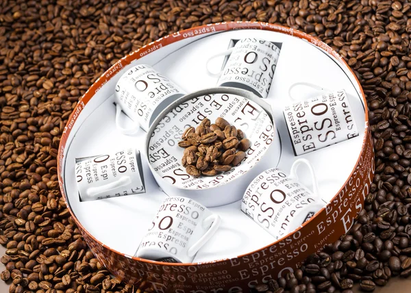 Xícaras de café armazenadas em uma caixa em grãos de café — Fotografia de Stock
