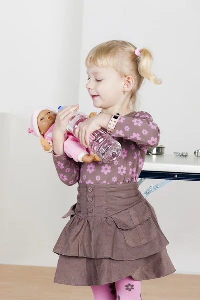 Niña jugando con una muñeca —  Fotos de Stock