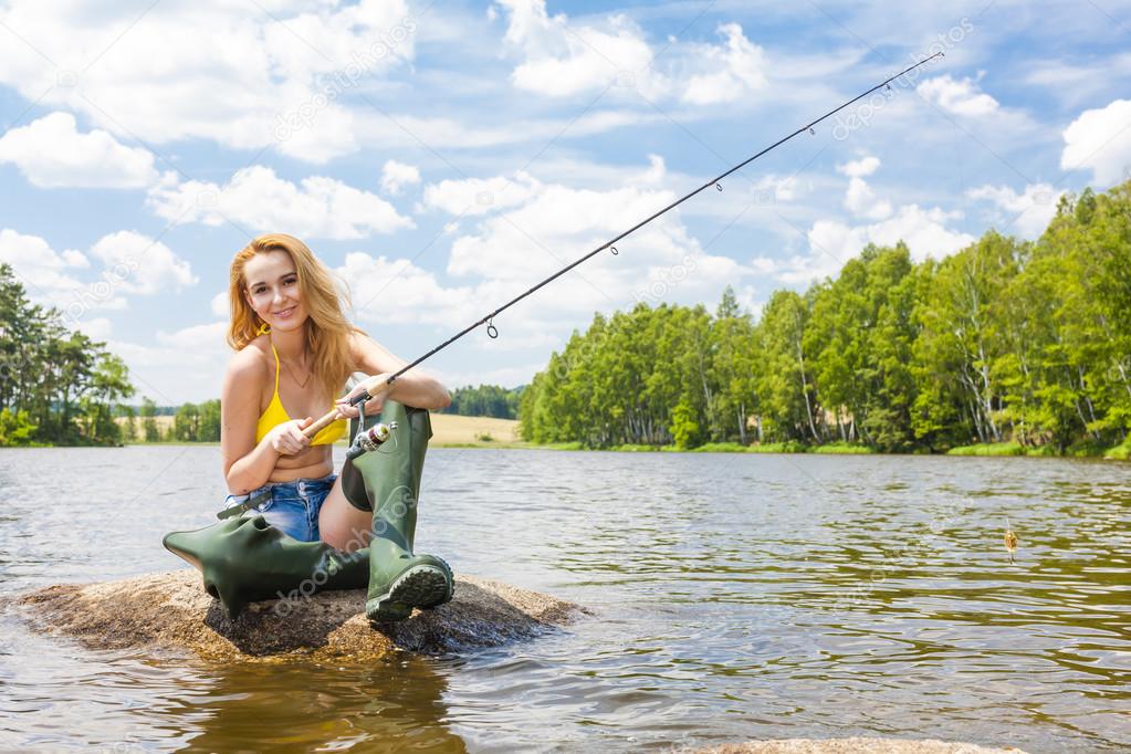 Woman fishing in pond during summer