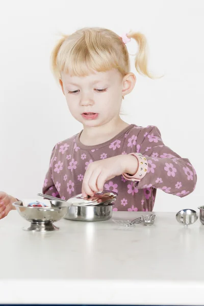 Little girl playing with child dish — Stock Photo, Image