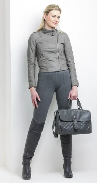 Mulher vestindo roupas cinza com uma bolsa — Fotografia de Stock