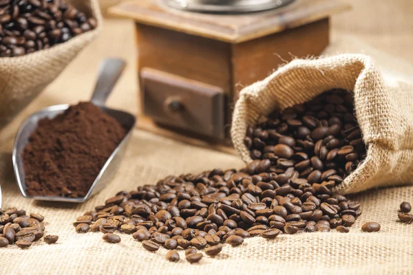 Vida ainda de grãos de café em sacos de juta com moedor de café — Fotografia de Stock