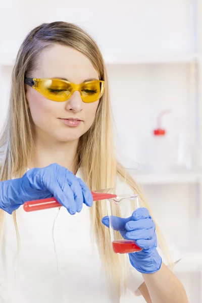 Ung kvinna gör experiment i laboratorium — Stockfoto