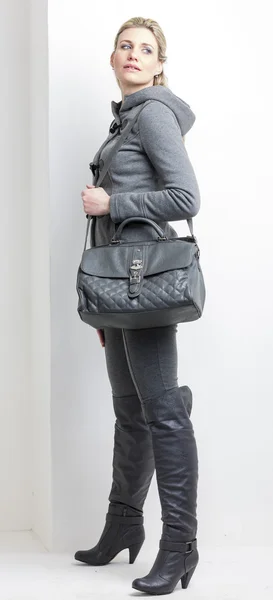 Femme portant des vêtements gris avec un sac à main — Photo