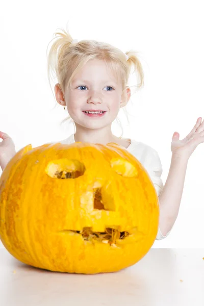 Liten flicka snidning pumpa till halloween — Stockfoto