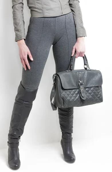 Λεπτομέρεια της όρθιας γυναικείας φορώντας γκρι μπότες με μια τσάντα — Φωτογραφία Αρχείου