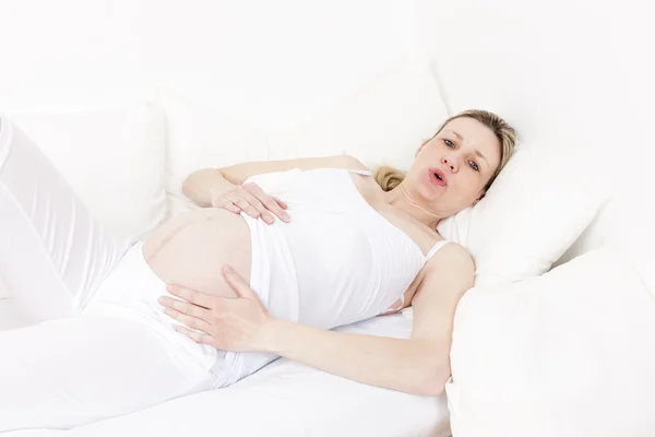 Mujer embarazada descansando y respirando en la cama —  Fotos de Stock