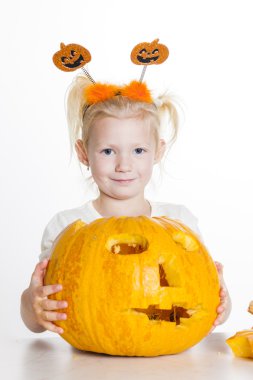 Cadılar Bayramı için balkabağı oyan kız.