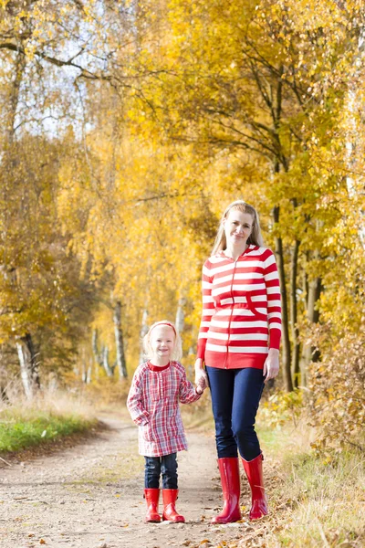 Moeder met haar dochter in herfst steegje — Stockfoto