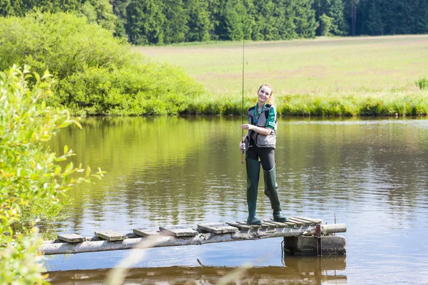 Vrouw vissen op de pier de vijver — Stockfoto