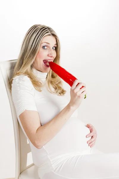 Pregnant woman eating red pepper — Stock Photo, Image