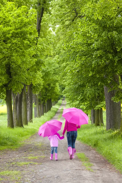 Mother and her daughter with umbrellas — Stock Photo, Image