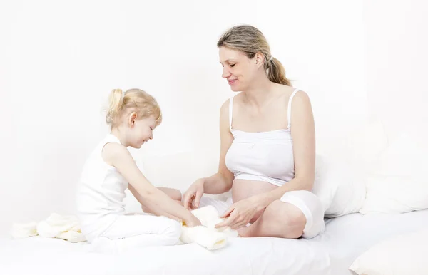 Kleines Mädchen und ihre schwangere Mutter — Stockfoto