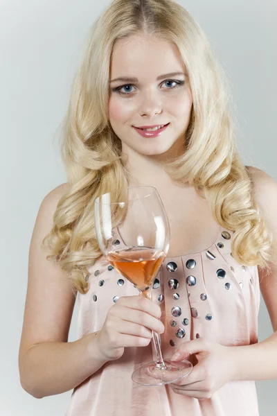Mladá žena se sklenkou růžové víno — Stock fotografie