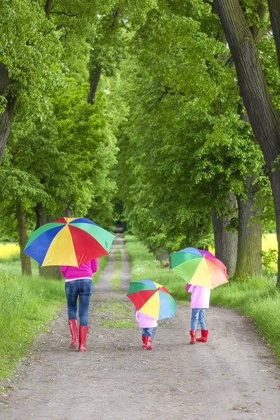 Mother and her daughters with umbrellas Royalty Free Stock Photos