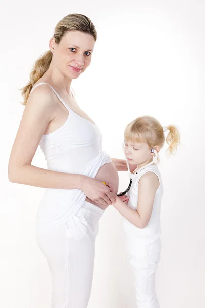 Meisje zorgzame na haar zwangere moeder — Stockfoto
