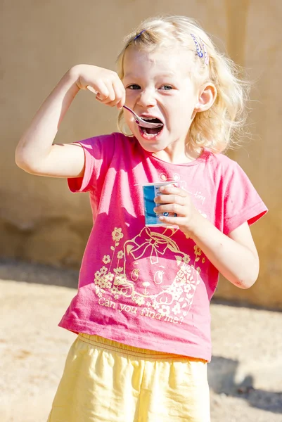 Liten flicka äter yoghurt — Stockfoto