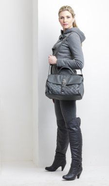 bir çanta ile gri elbise giyen kadın