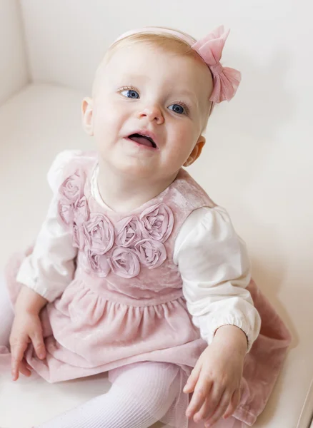 Portrait of sitting toddler girl wearing pink dress — Stock Photo, Image