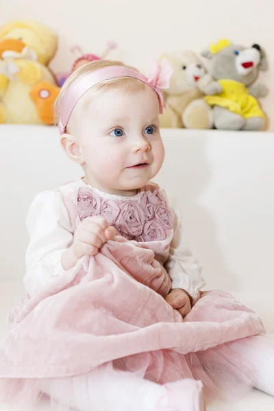 Portrait of sitting toddler girl wearing pink dress — Stock Photo, Image