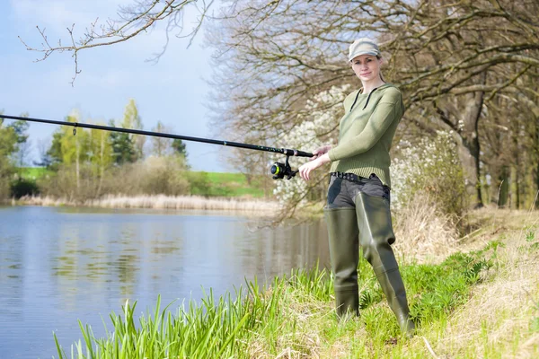 Woman fishing at pond in spring — Stock Photo, Image