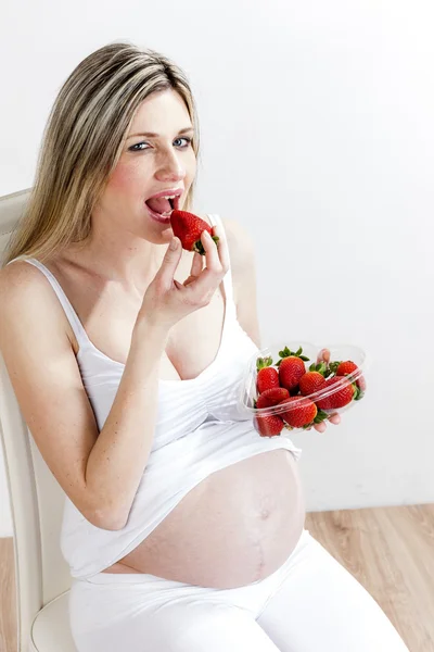 Portret van zwangere vrouw eten aardbeien — Stockfoto