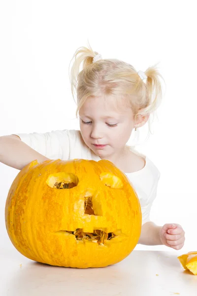 Liten flicka snidning pumpa till halloween — Stockfoto