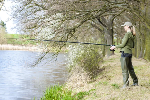 Mulher pesca na lagoa na primavera — Fotografia de Stock