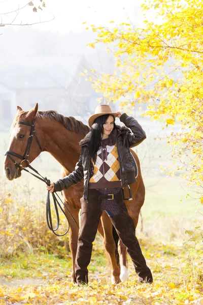 Ecuestre con su caballo en naturaleza otoñal — Foto de Stock