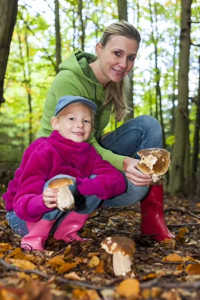 Mother with her daughter doing mushroom picking — Stock Photo, Image