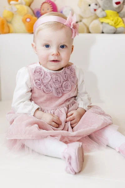 Retrato de niña sentada usando vestido rosa — Foto de Stock