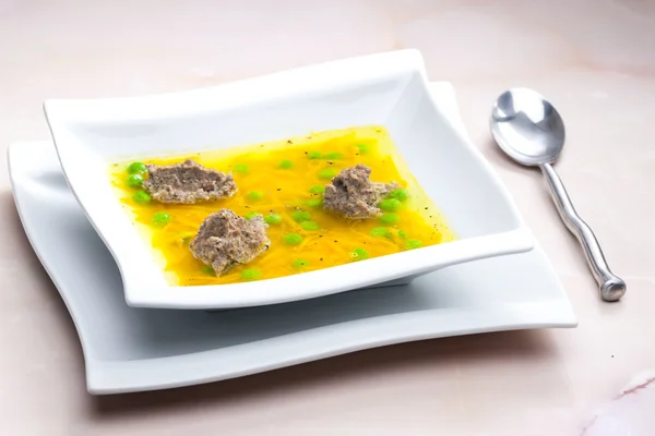 Homemade liver dumplings in chicken soup with carrots and peas — Stock Photo, Image