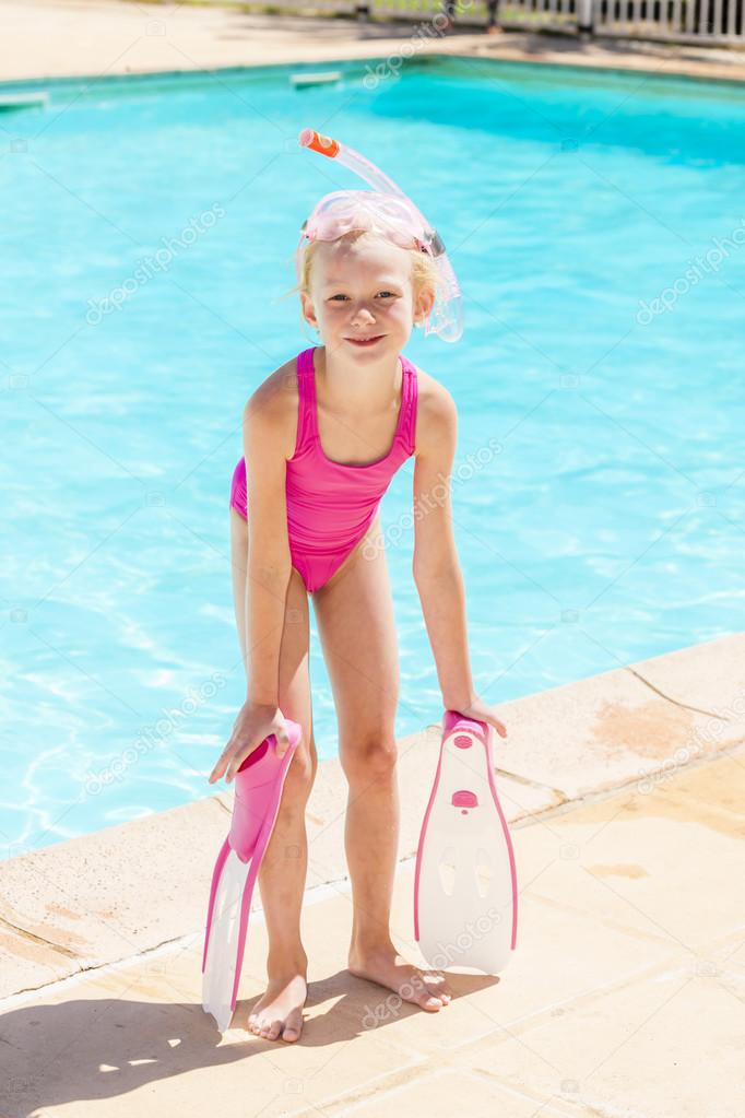 little girl with snorkeling equipment at swimming pool